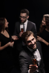 stylish young man raising a glass of wine