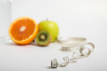 proper nutrition, fitness food, water, fruit, green apple, kiwi, orange. program of diet, dumbbells. concept of healthy food on a white background for advertising your text