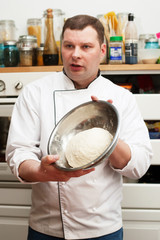 Food and people concept: male chef with cooked food standing in the kitchen.