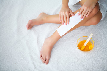 Waxing. Depilation legs with waxing and tape