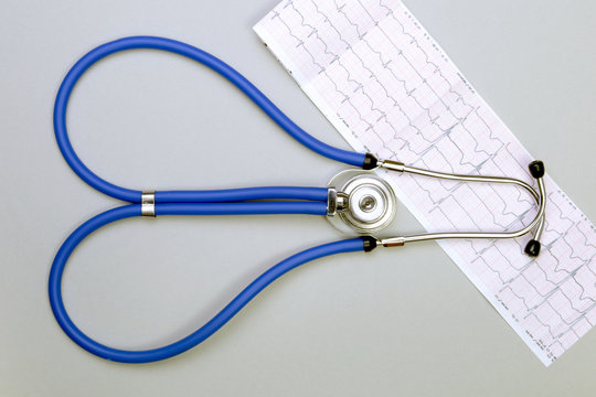 Stethoscope, red heart, RX prescription on white table with space for text.