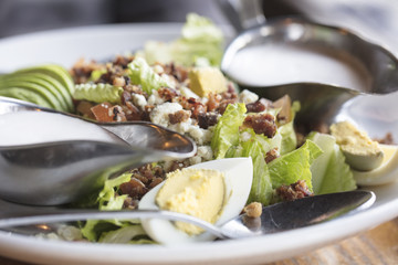 Dinner Cobb Salad made with romaine lettuce, tomatoes, eggs, avocado and bacon with ranch dressing on the side