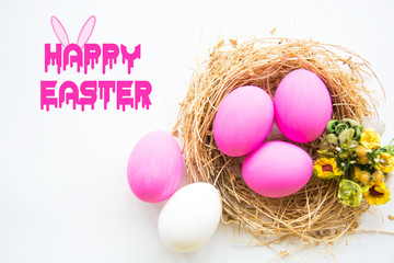 Pink colored Easter eggs in nest on wooden background, selective focus image. Happy Easter card 