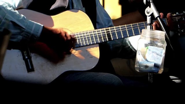 Country singer with acoustic guitar. A man is playing a guitar at an outdoor party.