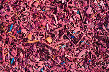 Textured background decorative colored sawdust for finishing flowerbeds in the winter season. Red and maroon sawdust