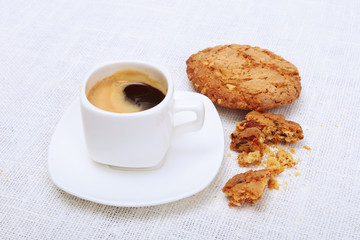 Classic espresso in white cup with cake and chocolate on white background.