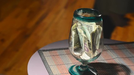 man putting dollar bill money in tips jar