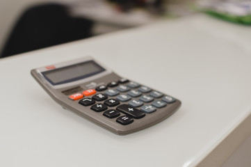 Closeup on calculator over light desk background. Top side view flat lay style of digital compute technology idea