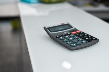 Closeup on calculator over light desk background. Top side view flat lay style of digital compute technology idea