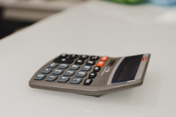 Closeup on calculator over light desk background. Top side view flat lay style of digital compute technology idea