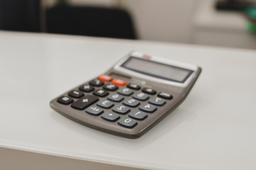 Closeup on calculator over light desk background. Top side view flat lay style of digital compute technology idea