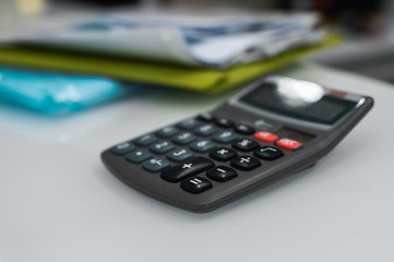 Closeup on calculator over light desk background. Top side view flat lay style of digital compute technology idea