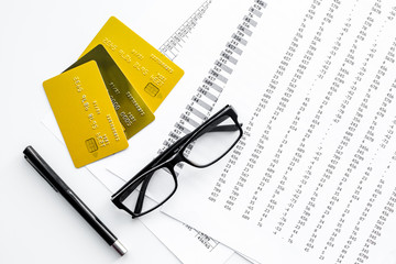 Bank cards for business. Pay bills by card. Bank cards near documents and glasses on white background top view