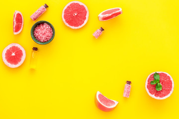 Organic cosmetic with grapefruit for homemade spa with salt and fresh fruit on yellow background top view mock-up