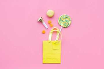 Gift concept. Sweets, paper bag for gift on pink background top view mock up