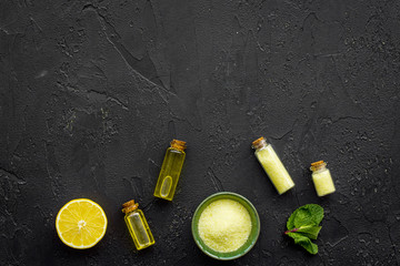 Natural cosmetics set with fresh lemon and organic oil on black table background top view mock up