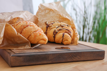 Tasty croissants on wooden board