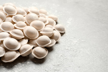 Raw dumplings on grey background