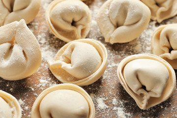 Raw dumplings on wooden background, closeup