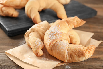 Tasty crescent rolls on wooden table