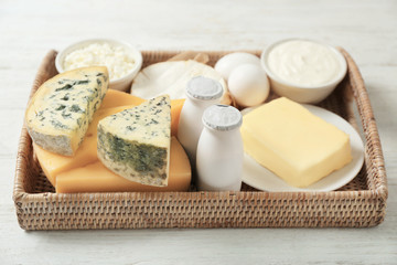 Tray with fresh dairy products and eggs on wooden background