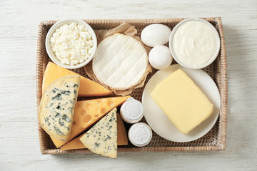 Tray with fresh dairy products and eggs on wooden background