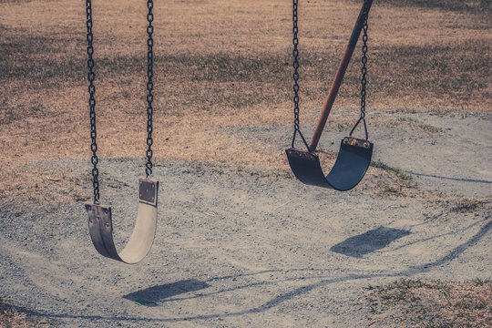 two  swings on old playground  , outdoor playground old photo style,