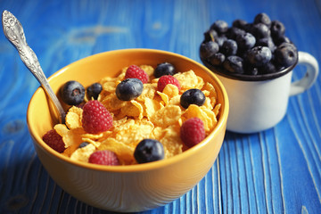 Cornflakes with berries raspberries and blueberries  on blue woo