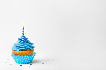 Birthday cupcake with candle on white background