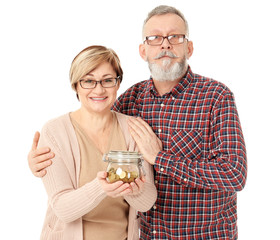 Happy senior man and his wife holding jar with coins on white background