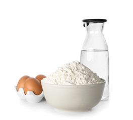 Wheat flour, eggs and bottle of water on white background