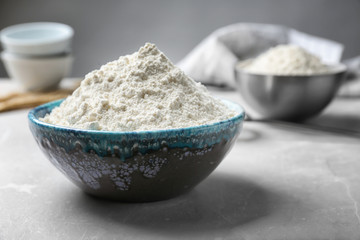 Ceramic bowl with flour on table