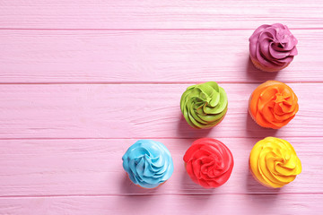 Delicious birthday cupcakes on wooden background