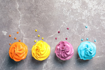 Delicious birthday cupcakes on gray background