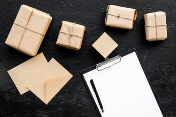 Parcels box and envelope in delivery service office black background top view space for text