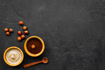 Treatment set with natural hazelnut scrub to take bath on dark background top view mock-up
