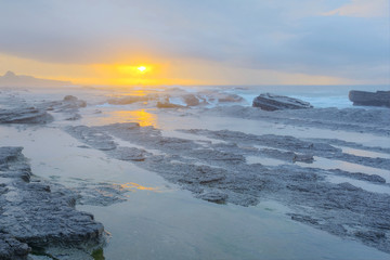 Dramatic sky with amazing red rosy cloud over the sea ~ Sunrise by the rocky coast in northern Taiwan ( Long Exposure Effect )