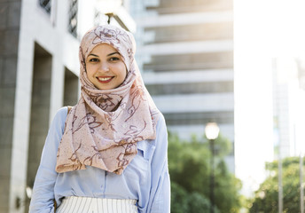 Islamic woman standing and smiling  in the city