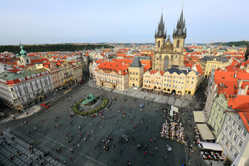 Fototapeta na wymiar Aerial view of Old Town Square in Prague, with the Church of Our Lady before Tyn among historical buildings, the Jan Hus Monument in the center and tourists enjoying their time on beautiful summer day