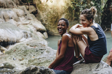 Friends hanging out by a waterfall in the jungle