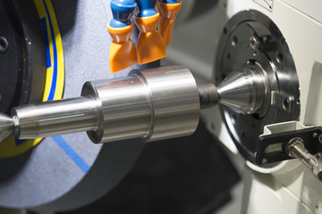 The CNC cylindrical grinding machine with the steel shaft.