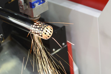 The CNC fiber laser cutting machine cutting the hole at the stainless pipe.