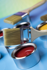 Paintbrush on cans with color