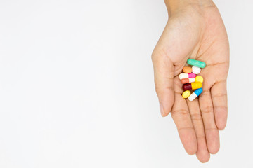 multiple colors pills in  hand  on white background.