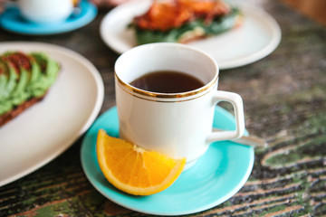 Obraz na płótnie Canvas A cup of aromatic useful tasty tea with an orange slice nearby. Useful and tasty breakfast.