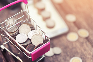 Online shopping concept. of mini shopping cart pink on blurred background with copy space.