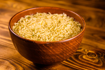Ceramic bowl with prepared instant noodles on wooden table