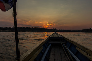Front view of Old fishing boat with Thailang flag and golden sunset as a background.