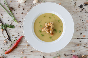 Cream soup on wooden table with bread