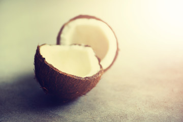 Cracked two halves of fresh organic coconut on grey background. Copy space